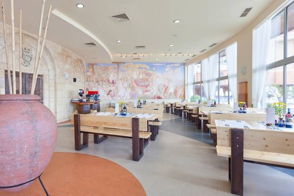 Restaurant im Sol Luna Bay All Inclusive Hotel mit gemauerten Wänden, großen Vasen und Holztischen.