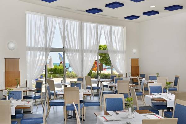 Innenansicht des Restaurants im Sol Luna Bay All Inclusive Hotel mit großen Fenstern und Blick auf den Strand.