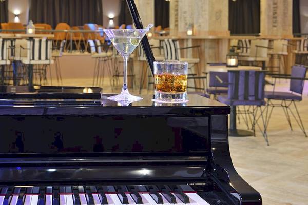 Ein Klavier mit einem Glas Martini und einem Glas Whiskey im Sol Luna Bay Hotel.