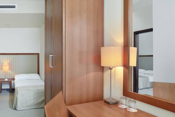 Doppelzimmer im Sol Luna Bay All Inclusive Hotel mit zwei Betten, Nachttischen und Lampen.