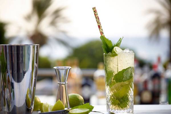 Cocktail auf einem Tisch im Rhodes Bay Hotel & Spa mit Mojito-Glas, Minzblättern und Zitronenscheiben.
