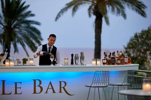 Barkeeper des Rhodes Bay Hotel & Spa serviert ein Getränk an der Bar.