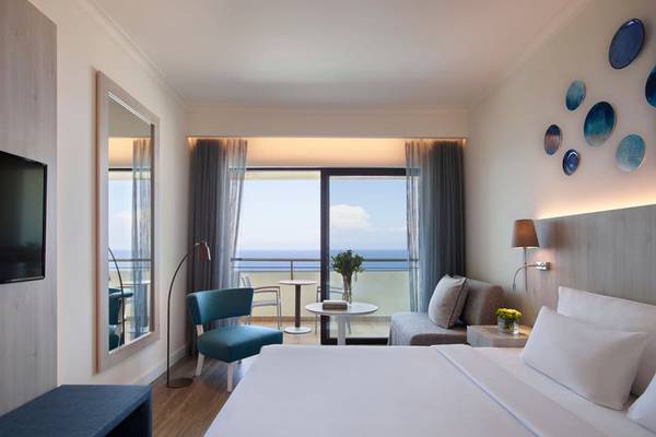 Innenansicht eines Schlafzimmers im Rhodes Bay Hotel & Spa mit Blick auf das Meer