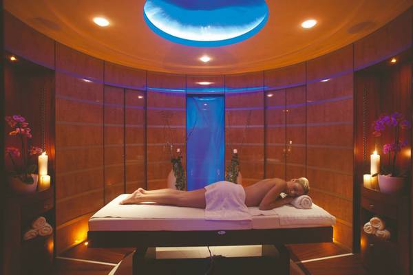 Behandlungsraum im Rhodes Bay Hotel & Spa mit einer Frau auf einer Massageliege.