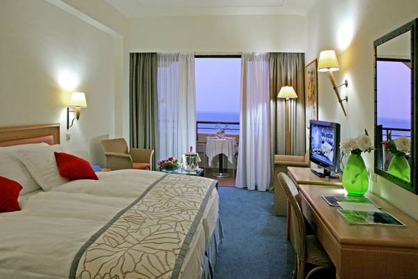 Zimmer im Rhodes Bay Hotel & Spa mit Meerblick, Bett, Schreibtisch und Balkon.