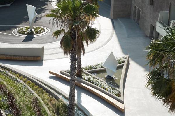 Aussenbereich des Rhodes Bay Hotel & Spa mit Palme, Brunnen und Garten