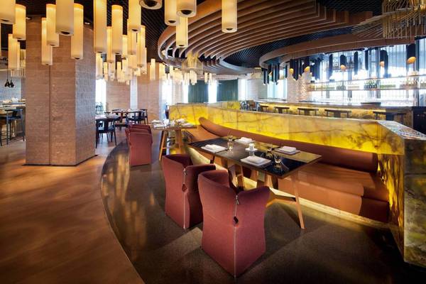 Innenansicht des Conrad Abu Dhabi Etihad Towers Restaurants mit runden Tischen und Stühlen.