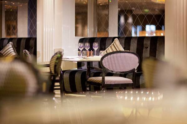 Innenansicht eines Restaurants im Conrad Abu Dhabi Etihad Towers Hotel mit gedeckten Tischen und Stühlen.