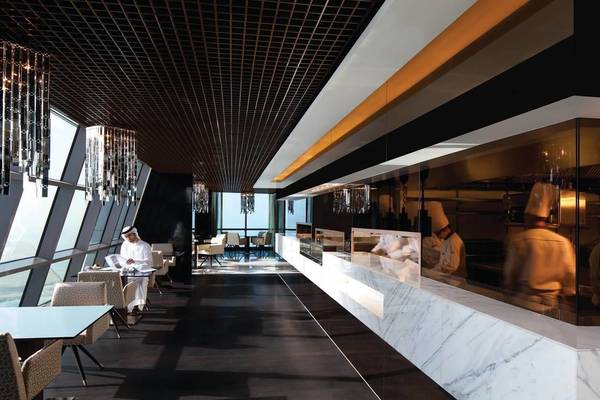 Innenansicht des Restaurants im Conrad Abu Dhabi Etihad Towers mit Küchenbereich und Tischen.