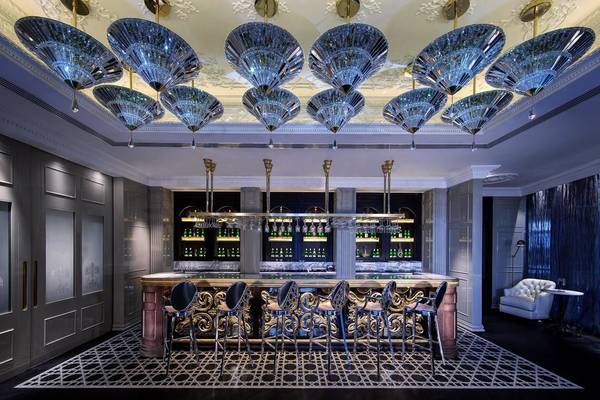 Innenansicht der Bar im Conrad Abu Dhabi Etihad Towers mit kristallenen Kronleuchtern und dekorativ gestalteten Barhockern.