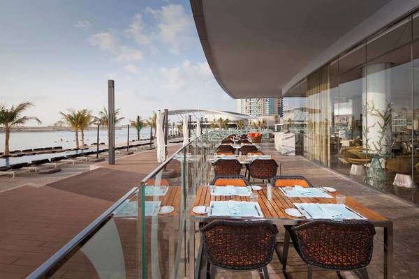 Terrasse des Conrad Abu Dhabi Etihad Towers mit Blick auf das Meer und Palmen