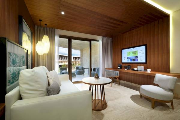 Wohnzimmerbereich des TRS Coral Hotels mit Sofa, Tisch, Fernseher und Deko.