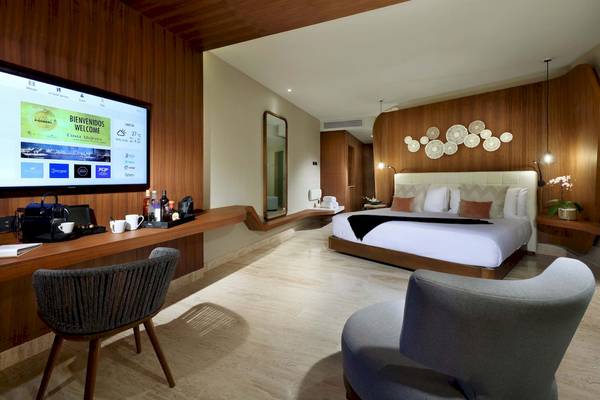 Innenansicht eines Zimmers im TRS Coral Hotel mit Bett, Fernseher und Schreibtisch