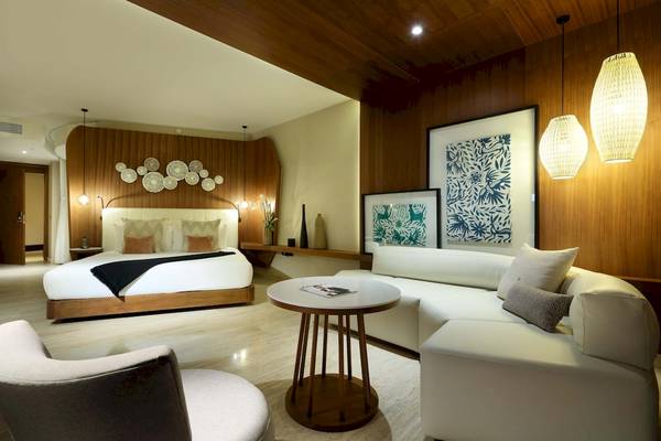 Innenansicht der Suite im TRS Coral Hotel mit Bett, Couch, Tisch und Dekor.