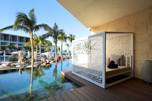 Außenbereich des TRS Coral Hotels mit Loungebereich am Pool und Palmen