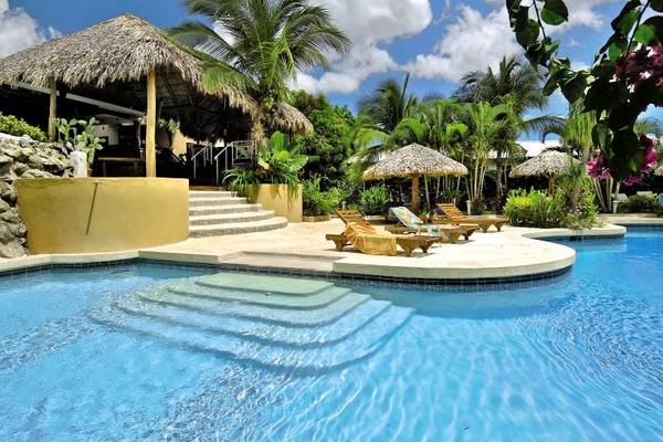 Poolbereich des Jardin del Eden Boutique Hotels mit Liegen und Sonnenschirmen.