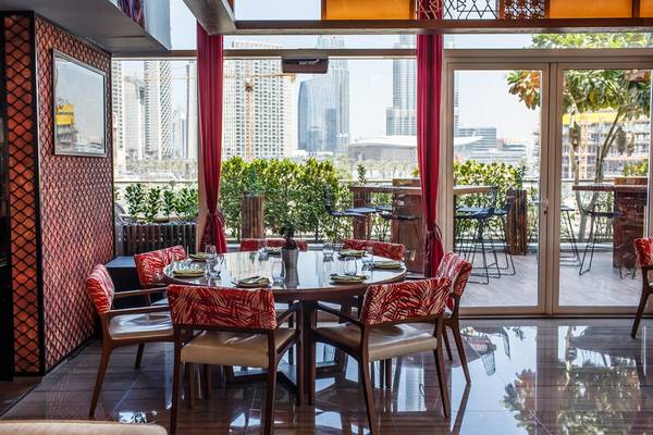 Innenbereich des Hotels Taj Dubai mit einem runden Esstisch und Blick auf die Stadt