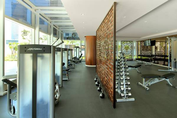 Fitnesscenter im Taj Dubai Hotel mit modernen Geräten und großem Fenster.
