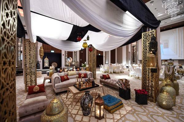 Innenbereich des Taj Dubai Hotels mit goldenen Dekorelementen, Möbeln und weißen Vorhängen.