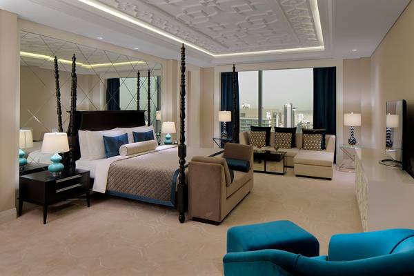 Schlafzimmer im Taj Dubai Hotel mit Himmelbett, Spiegel und Aussicht auf die Stadt.