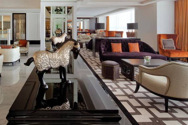 Lobby des Taj Dubai Hotels mit Möbeln, Lampen und einem Pferdekopf-Kunstwerk.