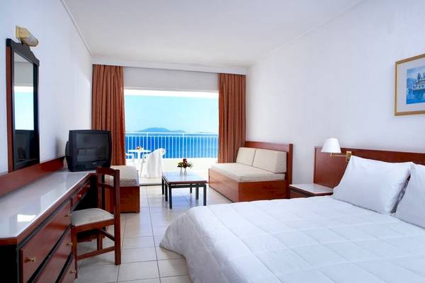 Hotelzimmer im Sunshine Corfu Hotel & Spa mit Meerblick, Bett, Sofa, Schreibtisch und Balkon.