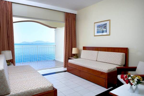Zimmer mit Balkon im Sunshine Corfu Hotel & Spa mit Blick auf das Meer und Möbeln.