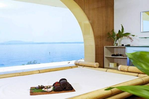 Suite mit Meerblick im Sunshine Corfu Hotel & Spa mit Bambusbett, Blick aufs Meer und Pflanzen im Zimmer.