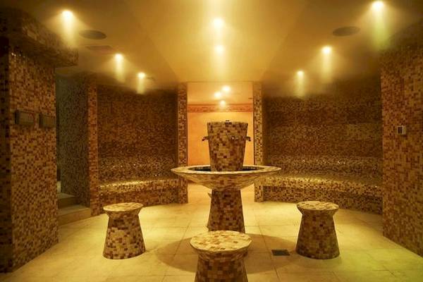 Saunaraum im Sunshine Corfu Hotel & Spa mit gefliesten Wänden und einer zentralen Brunneninstallation.