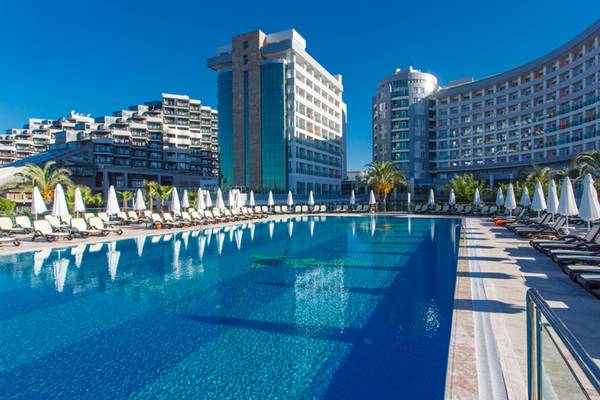 Außenpool des Sherwood Exclusive Lara Hotels mit Sonnenliegen und Palmen