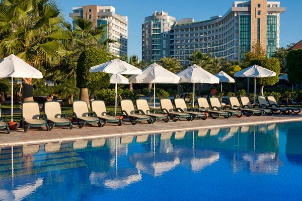 Pool mit Liegestühlen und Sonnenschirmen im Sherwood Exclusive Lara Hotel