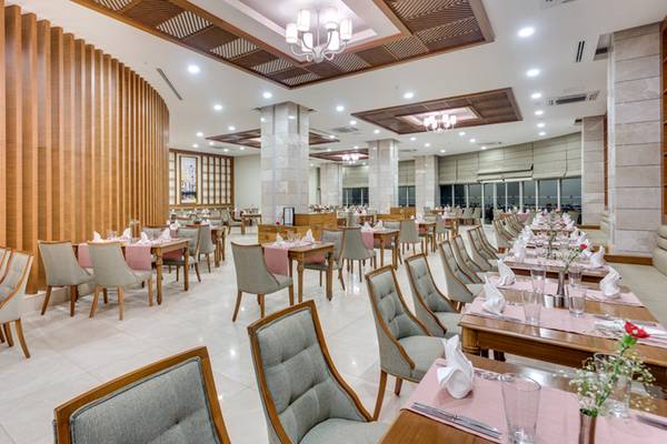 Innenansicht des Restaurants im Sherwood Exclusive Lara Hotel mit gedeckten Tischen und Stühlen.