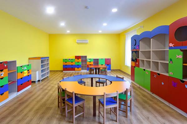 Kinderzimmer im Sherwood Exclusive Lara Hotel mit gelben Wänden und bunten Möbeln.