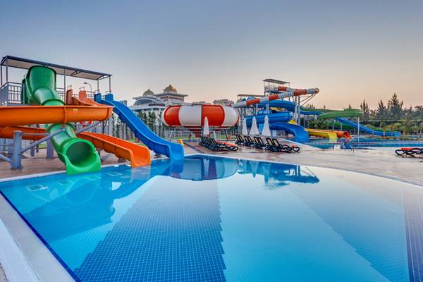 Wasserpark des Sherwood Exclusive Lara Hotels mit mehreren Wasserrutschen und Sonnenliegen.