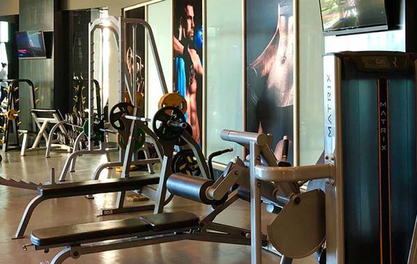 Fitnessstudio im Sherwood Exclusive Lara Hotel mit verschiedenen Trainingsgeräten und Monitoren.
