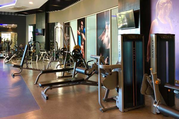 Fitnesscenter-Innenansicht im Sherwood Exclusive Lara Hotel mit verschiedenen Geräten und Plakaten.