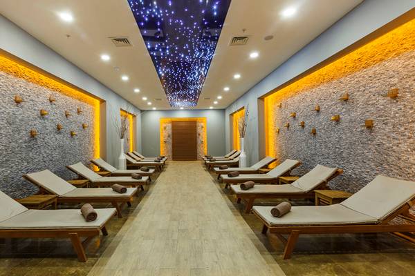 Relaxationsraum im Sherwood Exclusive Lara Hotel mit gepolsterten Liegen und Steinwänden.