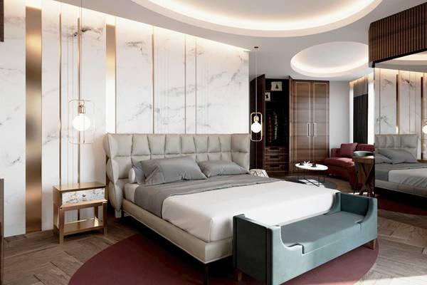 Schlafzimmerdesign im Sherwood Exclusive Lara Hotel mit Marmorwänden, Rundbett, grauen Kissen und einem runden Tisch.