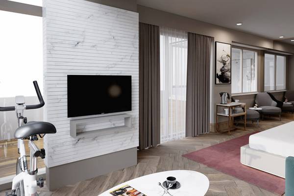 Innenansicht eines Zimmers im Sherwood Exclusive Lara Hotel mit Fernseher, Fitnessgeräten und Möbeln.