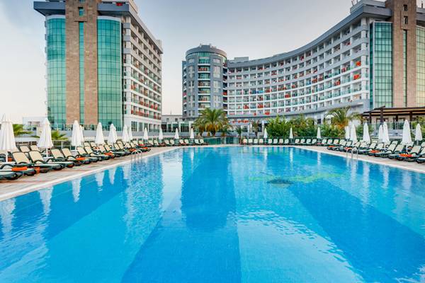 Außenpool des Sherwood Exclusive Lara Hotels mit vielen Liegen und Sonnenschirmen.
