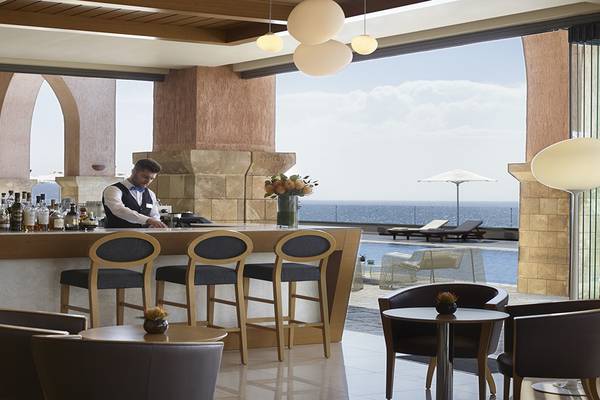 Barbereich des Boutique 5 Hotel & Spa mit Blick auf das Meer und Liegestühlen.