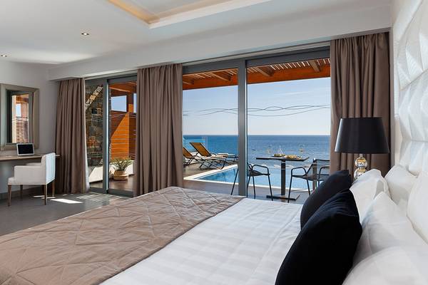 Ein elegantes Zimmer im Boutique 5 Hotel & Spa mit Blick auf den Ozean und einer Terrasse davor.