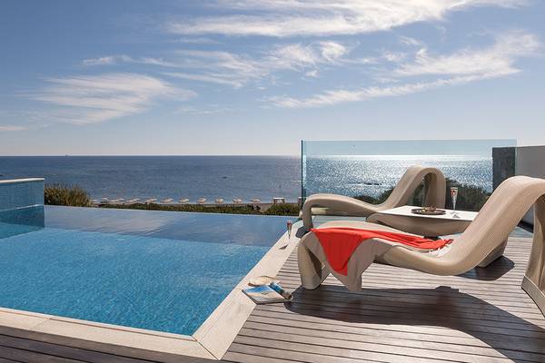 Aussicht vom Boutique 5 Hotel & Spa auf den Ozean und einen Pool mit Lounge-Liegestühlen.