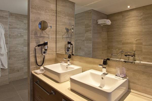 Badezimmer im Boutique 5 Hotel & Spa mit zwei Waschbecken, Spiegeln und Handtüchern.