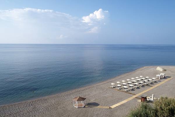 Ausblick auf den Strand vom Boutique 5 Hotel & Spa mit Sonnenschirmen und Meer.