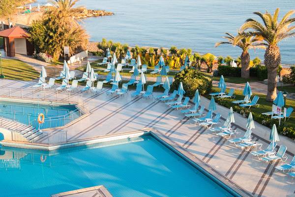 Oberirdischer Blick auf den Poolbereich des Creta Star Hotels mit blauen Liegestühlen und Sonnenschirmen.