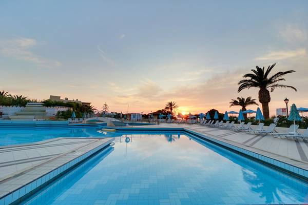 Schwimmbad des Creta Star Hotels bei Sonnenuntergang mit blauem Wasser und Sonnenlicht