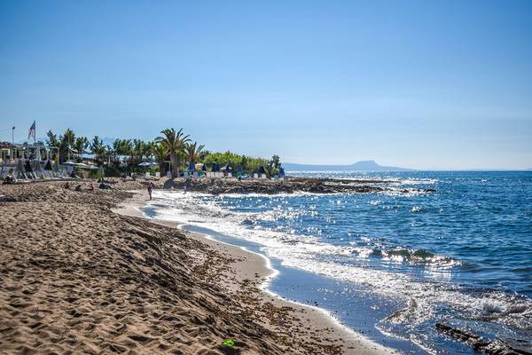 Strand des Creta Star Hotels mit blauem Wasser und Sonnenschirmen
