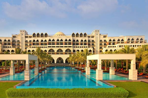 Außenbereich des Jumeirah Zabeel Saray Hotels mit Swimmingpool und Loungestühlen