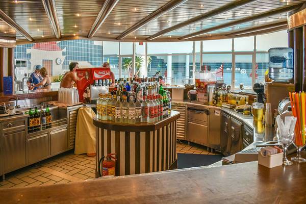 Innenansicht der Bar im Hotel Creta Star mit vollbestückten Regalen und Kunden.
